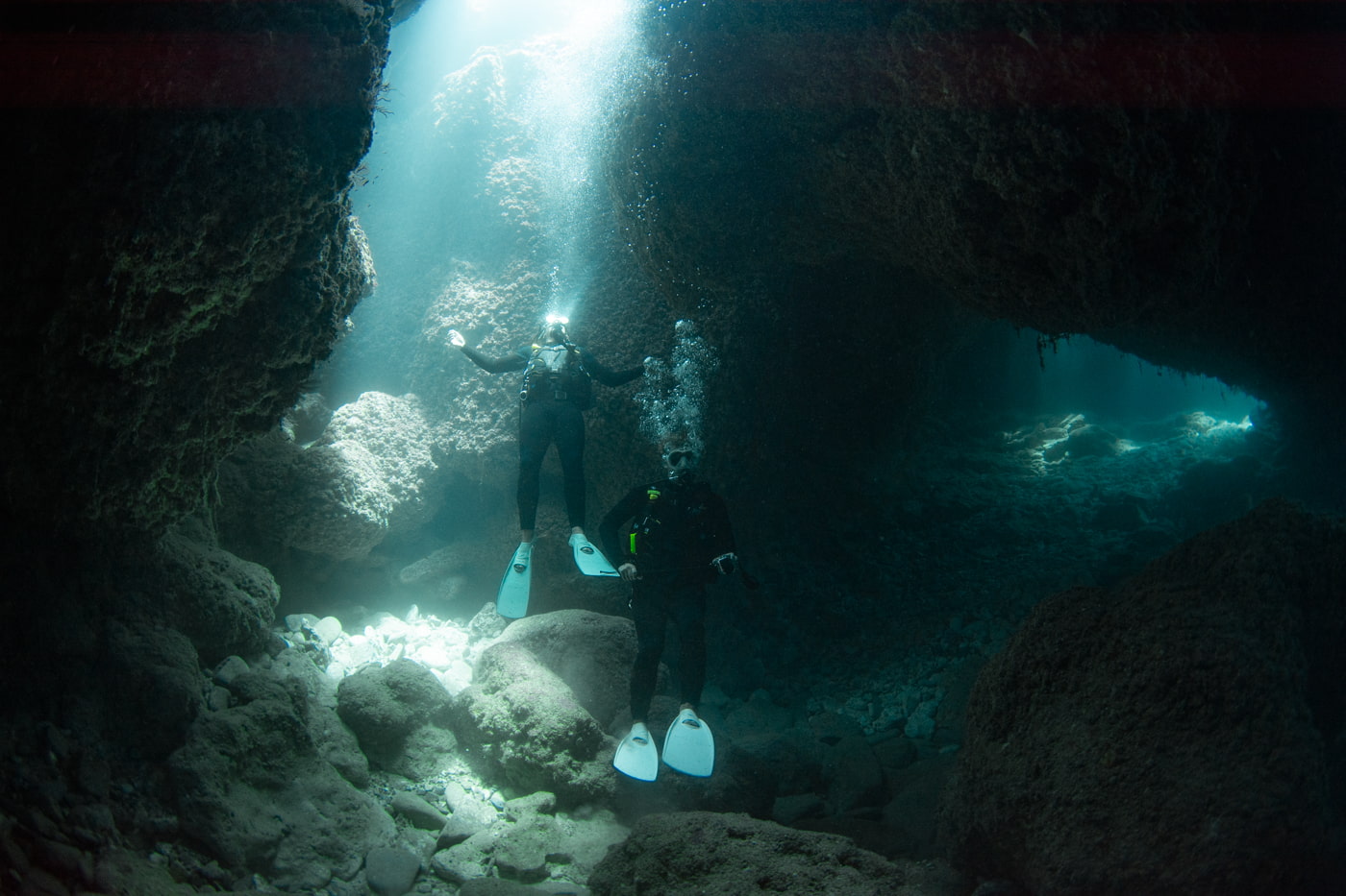 Guests diving inside a cave.